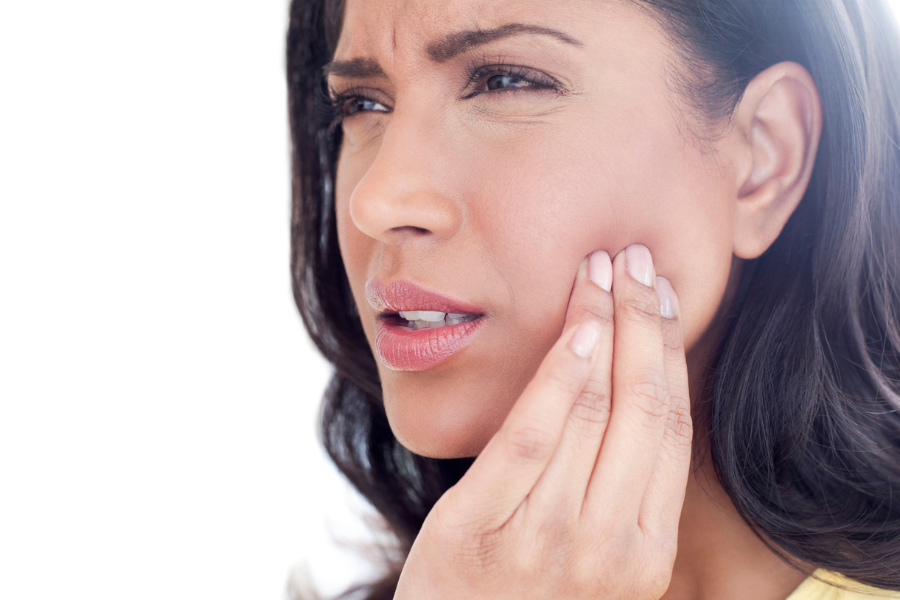 Person experiencing jaw discomfort associated with TMJ symptoms