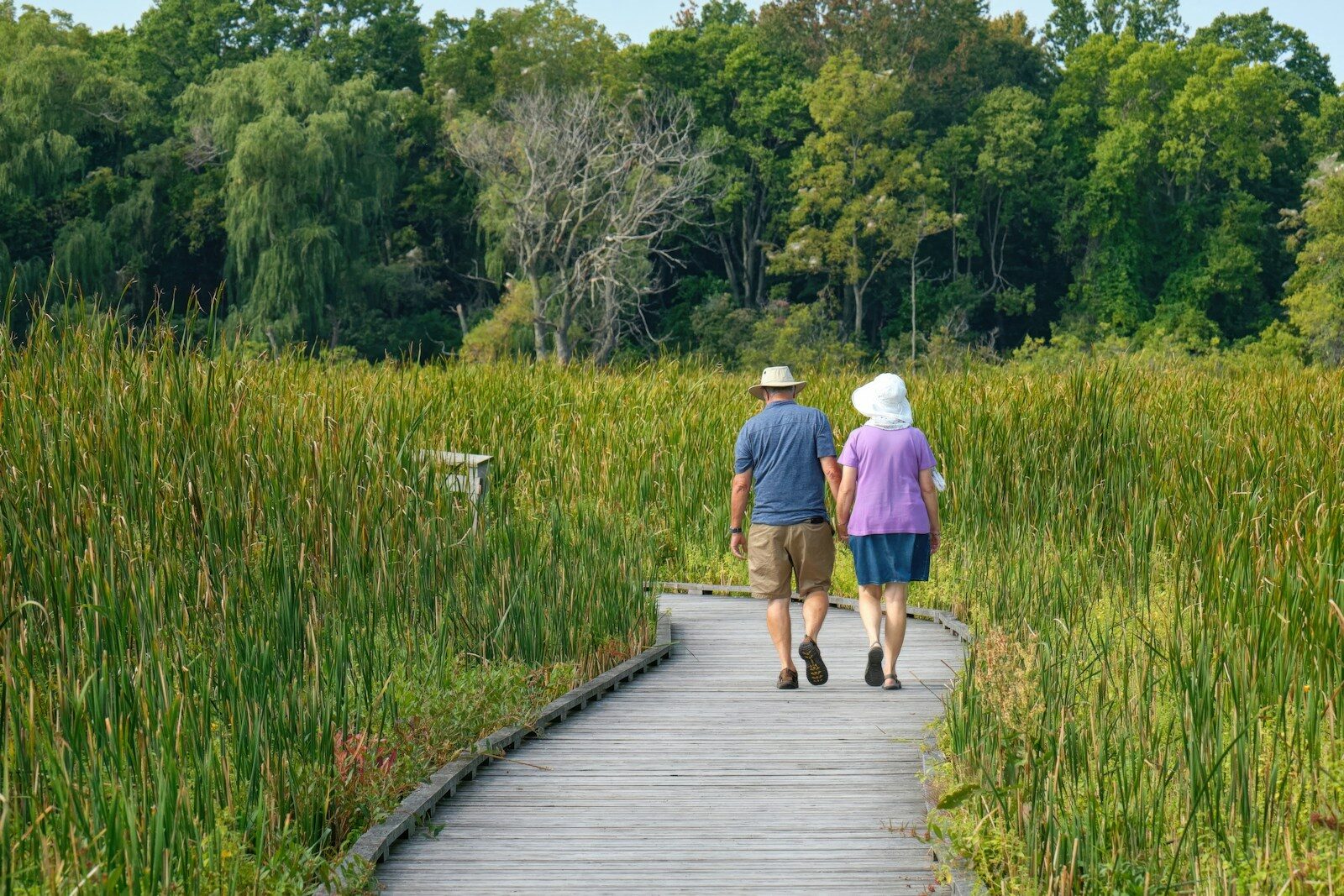 Older couple walking outdoors on a boardwalk